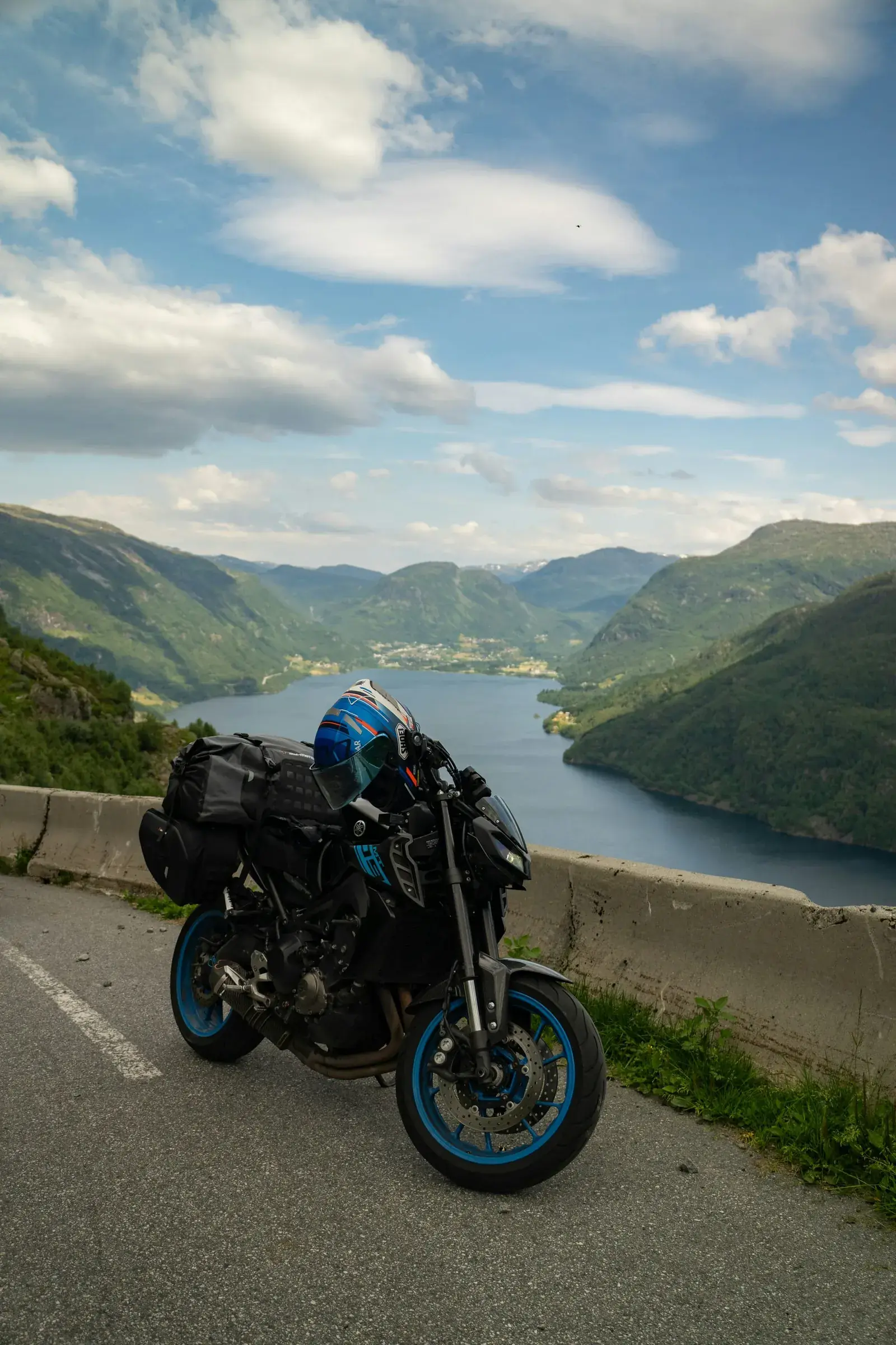 Motorcykel parkeret ved en fjord med bjerge
