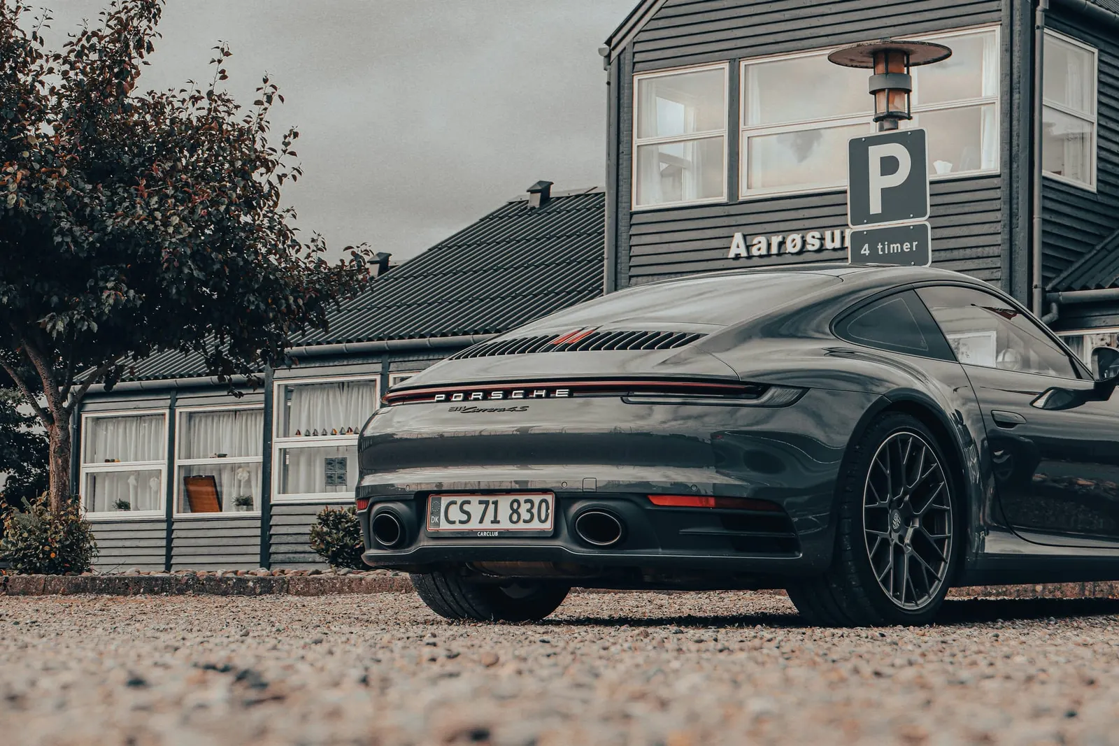 Sportsvogn parkeret foran en bygning ved havnen
