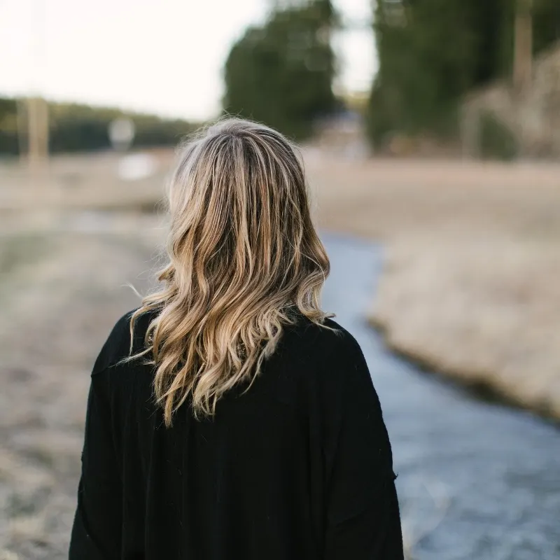 Kvinde går på en sti gennem et åbent landskab