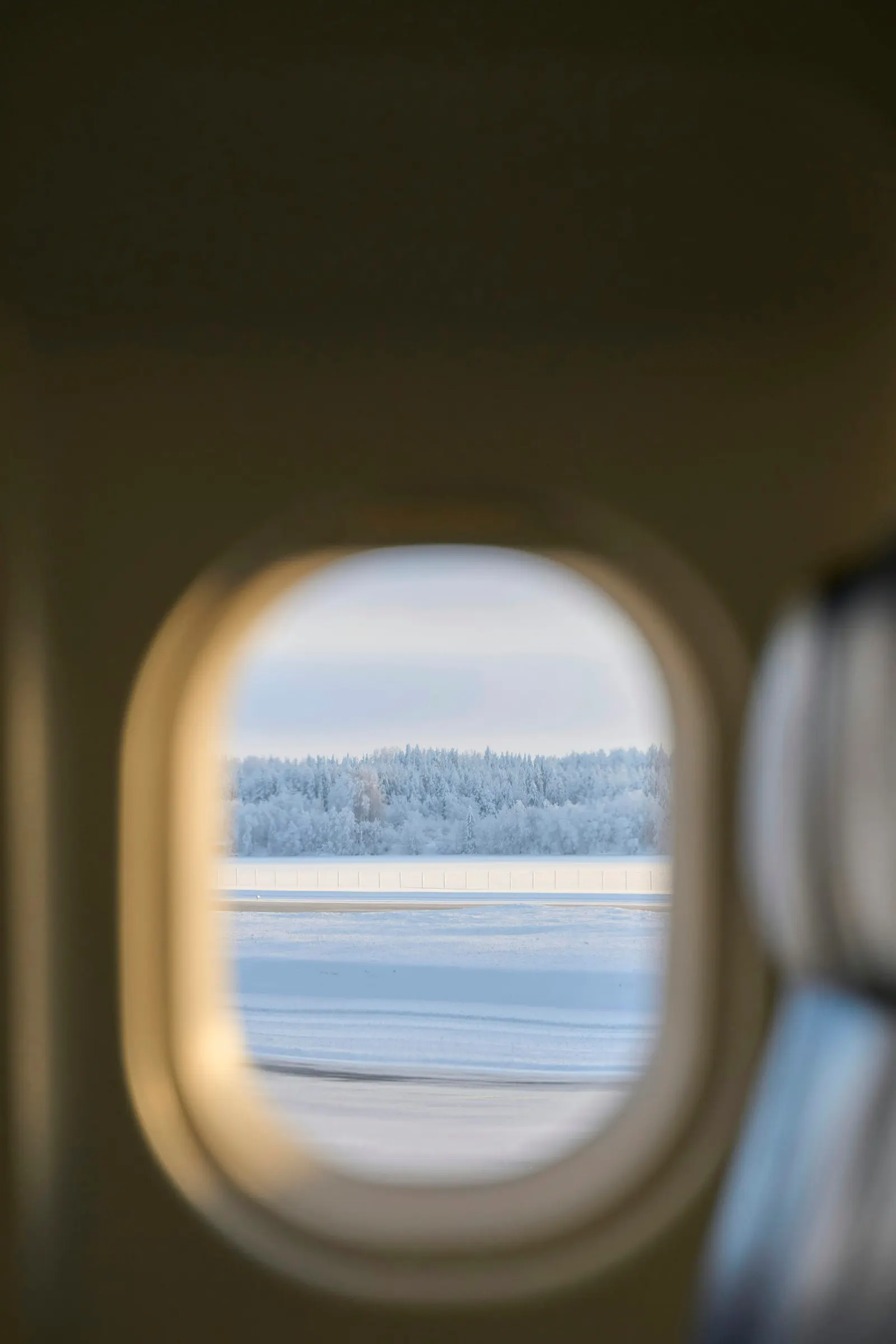 Udsigt til et vinterlandskab gennem et flyvindue