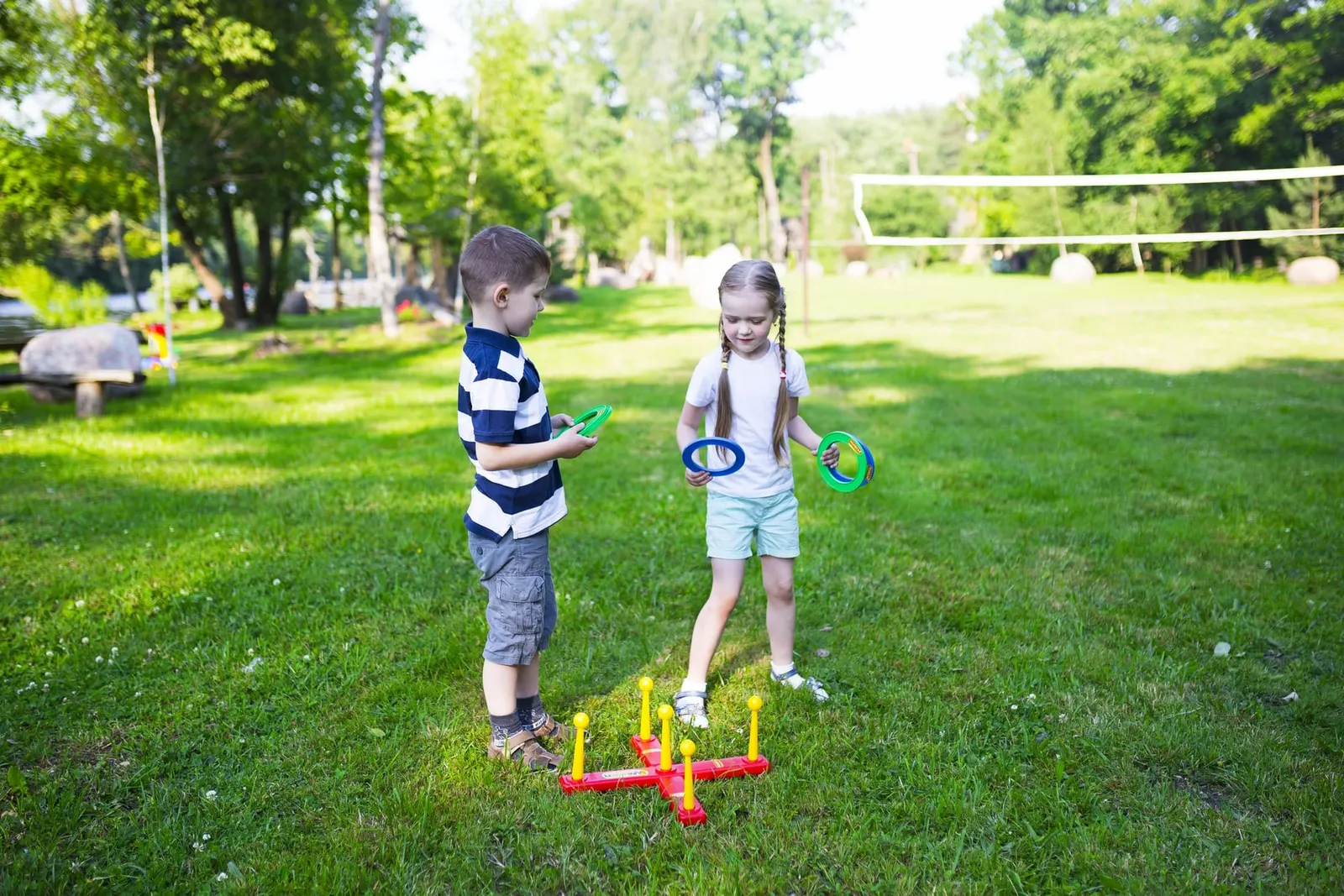 To børn spiller på en græsplæne i en park